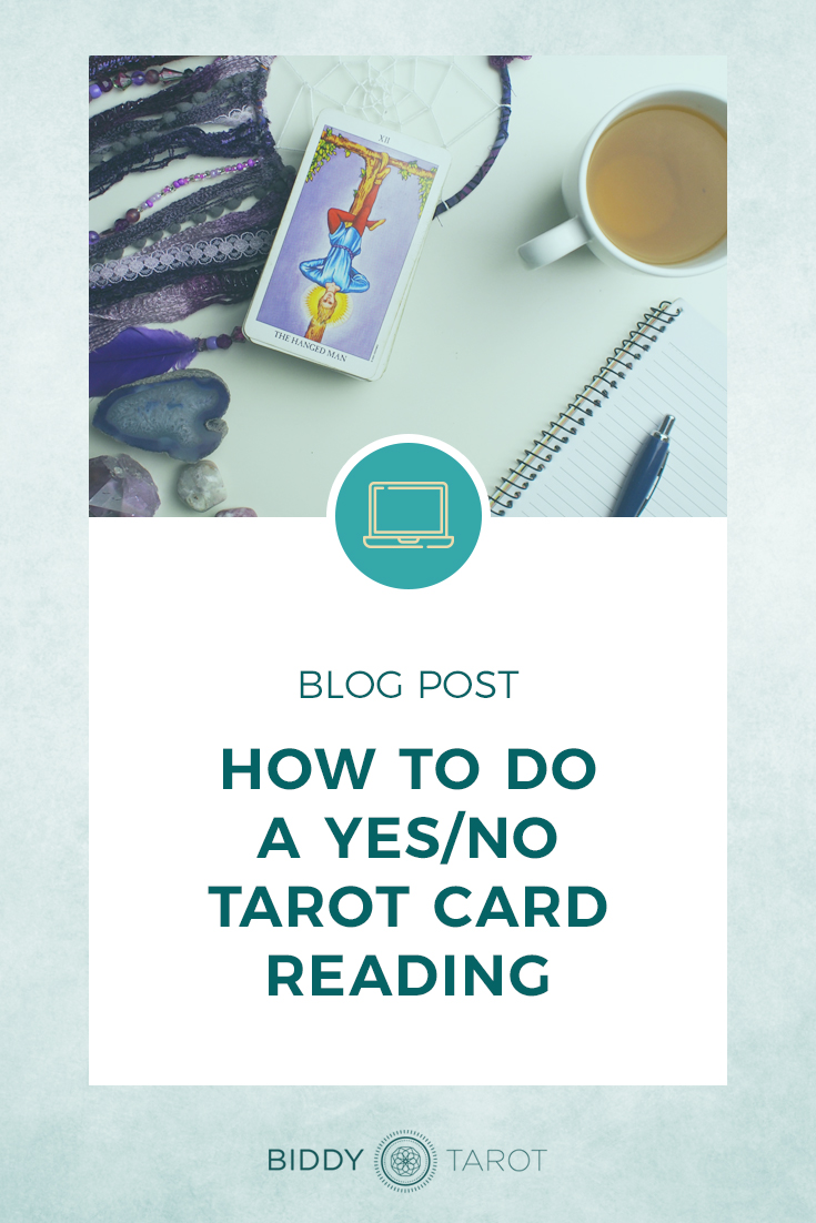 How to do a Yes/No Tarot Card Reading | Biddy Tarot | The Hanged Man from the Radiant Rider Waite Tarot Deck and a cup of tea with a dream catcher, along with a pen and notebook.